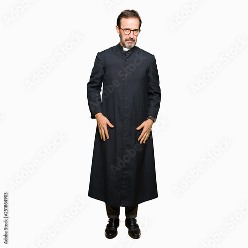 Middle age priest man wearing catholic robe skeptic and nervous, frowning upset because of problem. Negative person.
