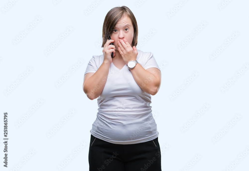 Young adult woman with down syndrome taking using smartphone over isolated background cover mouth with hand shocked with shame for mistake, expression of fear, scared in silence, secret concept Young adult woman with down syndrome taking using smartphone over isolated background cover mouth with hand shocked with shame for mistake, expression of fear, scared in silence, secret concept