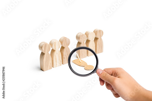 Φωτογραφία Magnifying glass is looking at a fake person falls out of the line of human figures