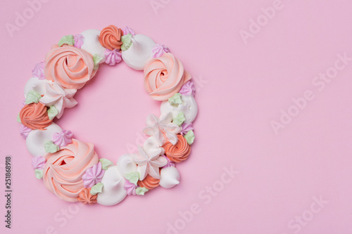 wreath of colored meringues on a pink pastel background, the concept of summer and holiday