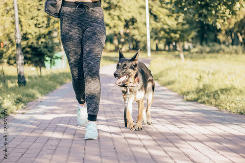 woman jogging in the park with a German shepherd