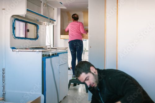 Foto Young couple painting and restoring caravan