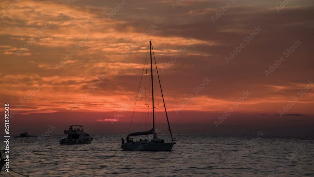 A sailing boat is slowly moving on the water on a nice summer evening A sailing boat is slowly moving on the water on a nice summer evening