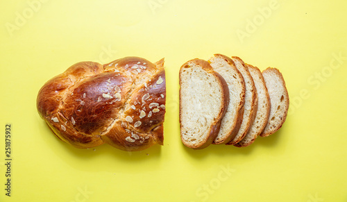 Easter bread, greek tsoureki braid on yellow color, top view photo