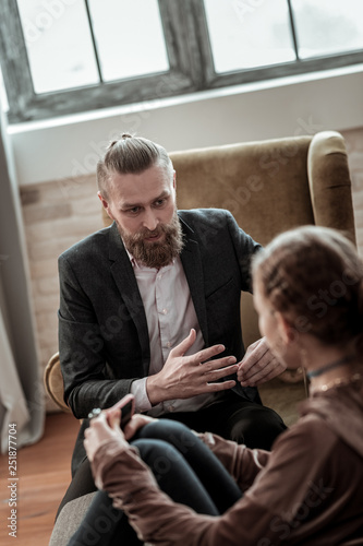 Bearded psychologist giving instructions to stressed teenager