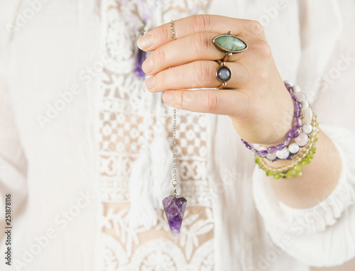 Quadro em tela Spiritual healer using purple natural Amethyst crystal quartz pendulum