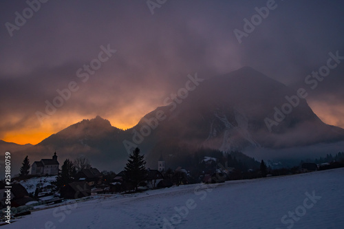 View from village Puergg to dramatic sunset over mountain Grimming photo