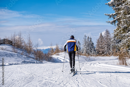 Man during cross-country skiing in sunny winter wonderland in Austria