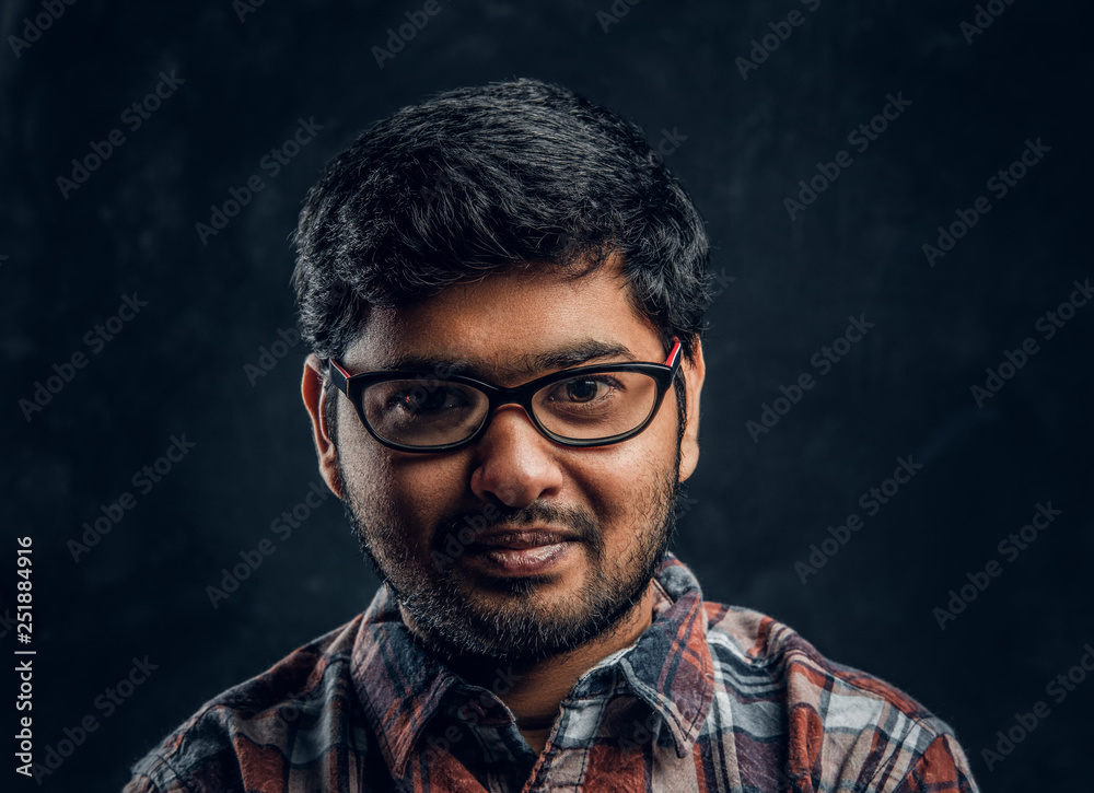 Portrait of a dark skinned chubby guy looking into a camera in a studio on a black background Portrait of a dark skinned chubby guy looking into a camera in a studio on a black background