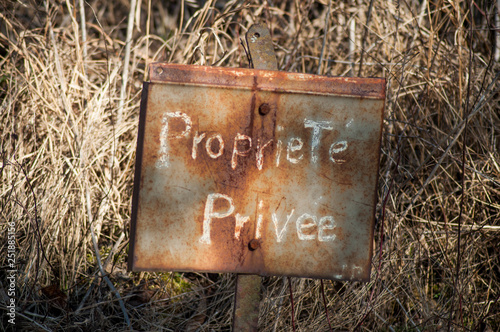 closeup of private property on rusty panel , text in french (propriete privee) traduction in english private property photo