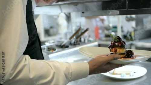 Waiter serving in motion on duty in restaurant photo