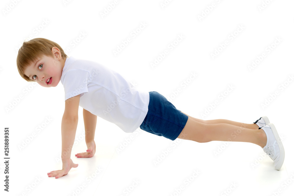 A little boy in a clean white T-shirt is engaged in fitness. A little boy in a clean white T-shirt is engaged in fitness.