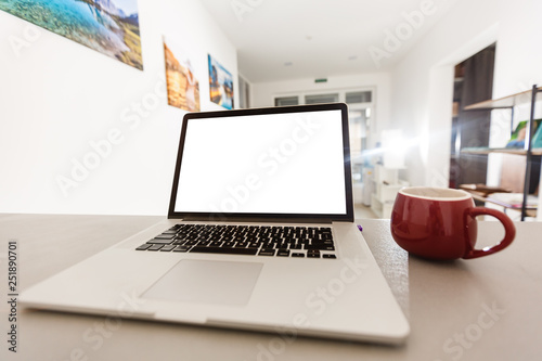Fototapeta Naklejka Na Ścianę i Meble -  Laptop with blank screen on white table with mouse and smartphone. Home interior or office background