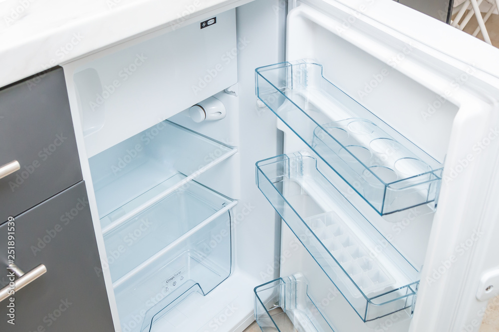 Empty opened refrigerator with clean glass shelves. Close up. Empty opened refrigerator with clean glass shelves. Close up.