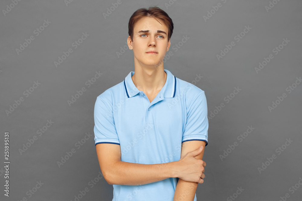 Freestyle. Teenager boy standing isolated on grey looking aside sad Freestyle. Teenager boy standing isolated on grey looking aside sad