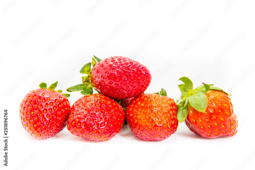 Several red strawberries with leaves on a white background Several red strawberries with leaves on a white background