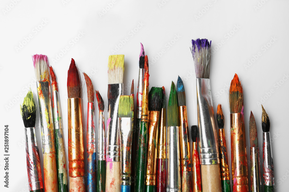 Obraz premium Different paint brushes on white background, top view