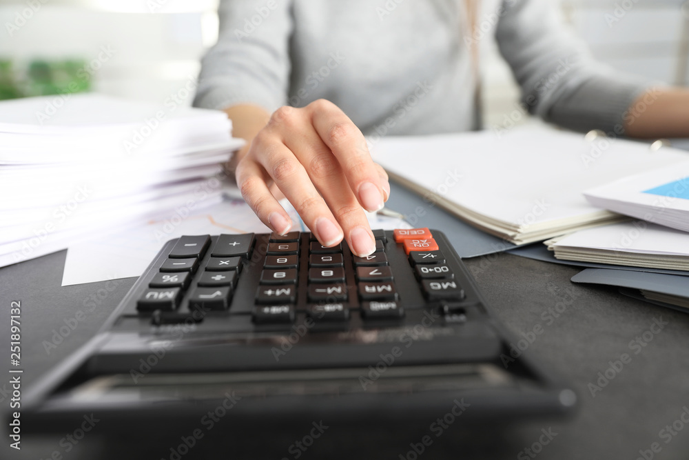 Office employee working with calculator and documents at table, closeup Office employee working with calculator and documents at table, closeup