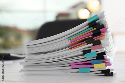 Stack of documents with paper clips on office table