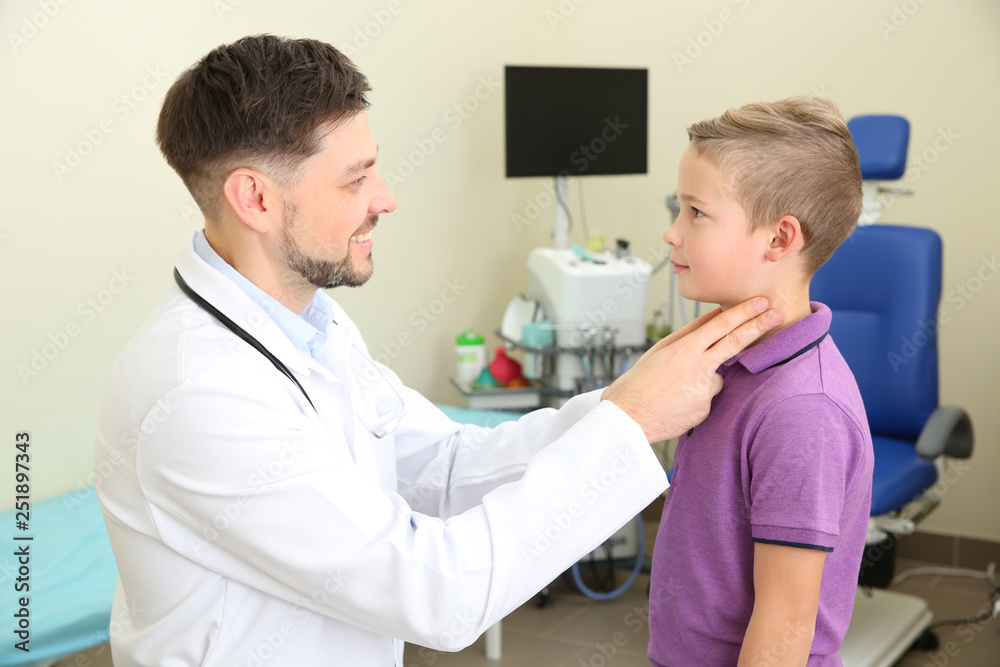 Male otolaryngologist examining little child in hospital