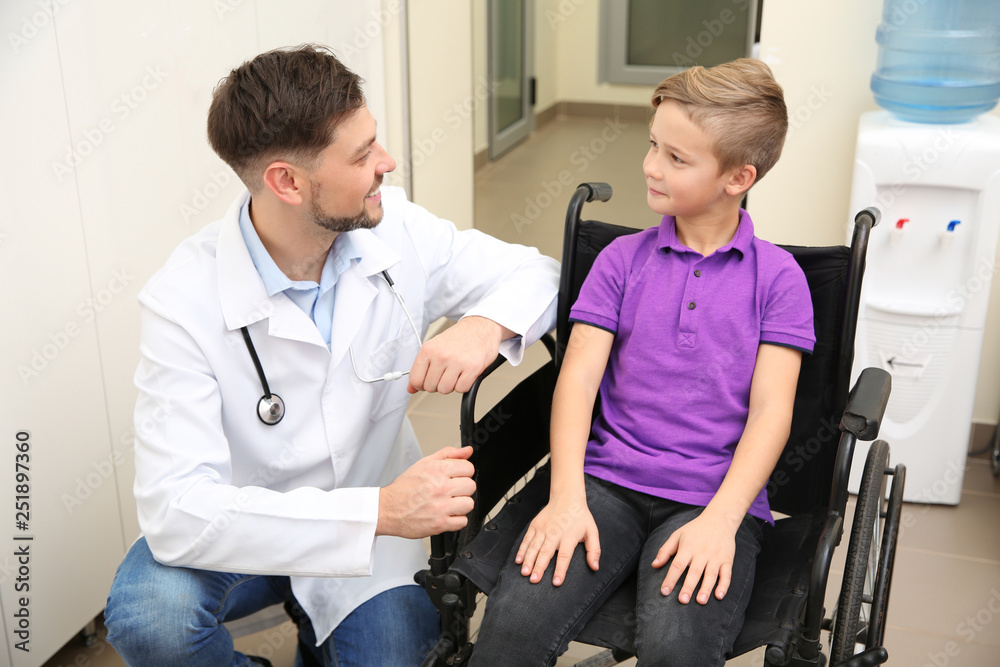 Doctor and little child in wheelchair at hospital Doctor and little child in wheelchair at hospital