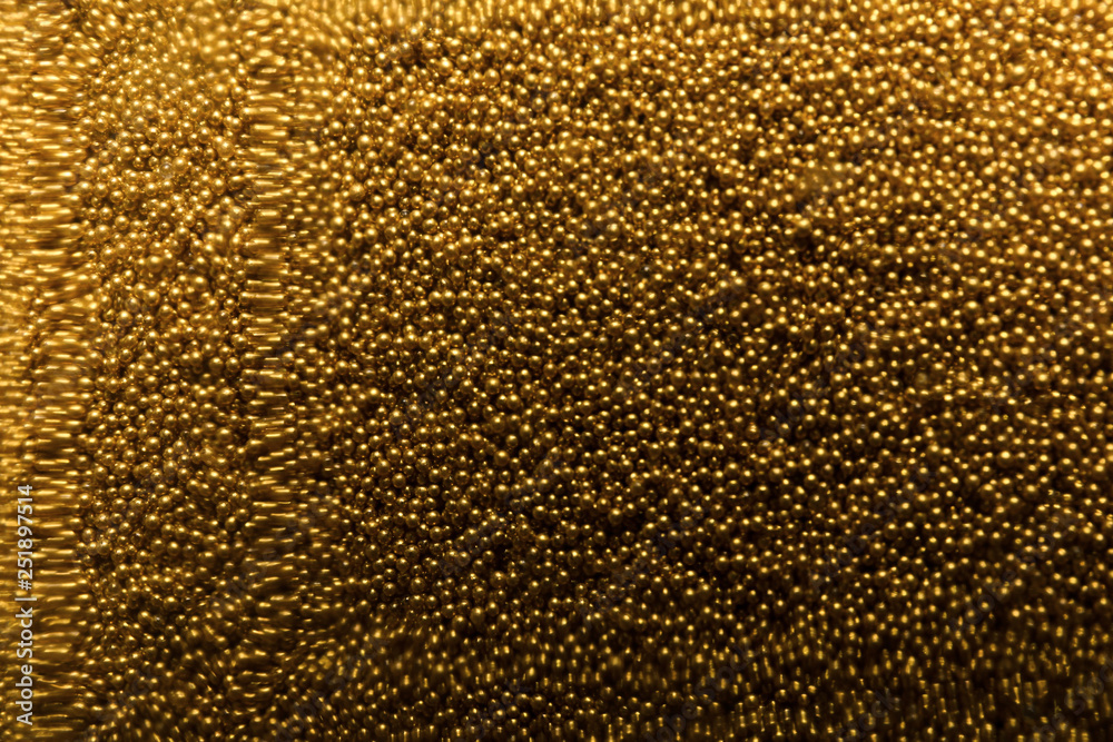 Many gold beads as background, view through glass Many gold beads as background, view through glass