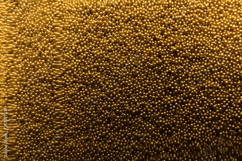 Many gold beads as background  view through glass