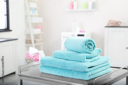 Soft bath towels on table against blurred background, space for text
