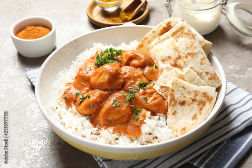 Tableau sur toile Delicious butter chicken with rice in plate on table