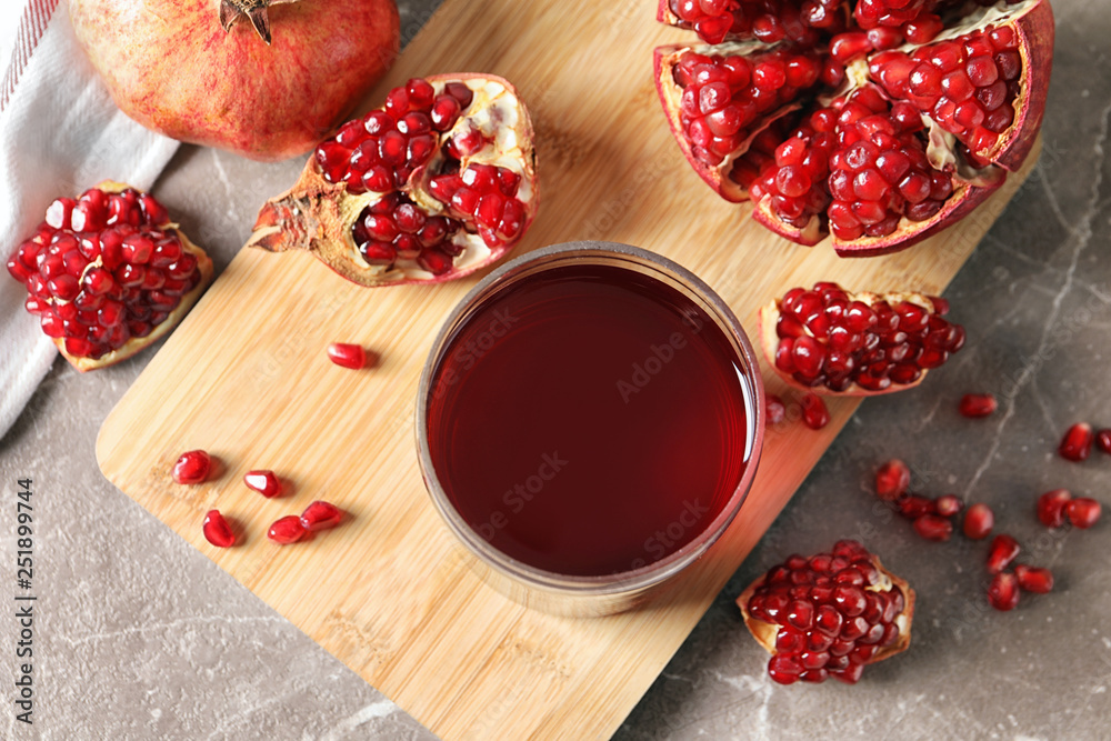 Flat lay composition with pomegranate juice, fruit and seeds on table Flat lay composition with pomegranate juice, fruit and seeds on table
