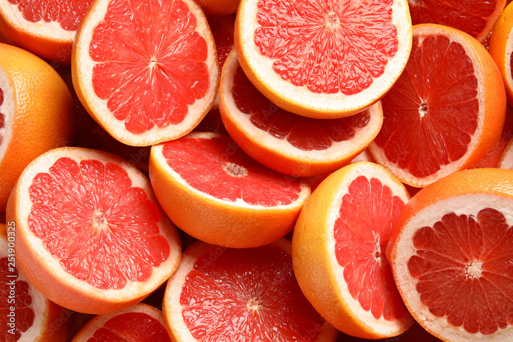 Many sliced fresh grapefruits as background, top view Many sliced fresh grapefruits as background, top view