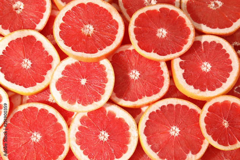 Many sliced fresh grapefruits as background, top view Many sliced fresh grapefruits as background, top view