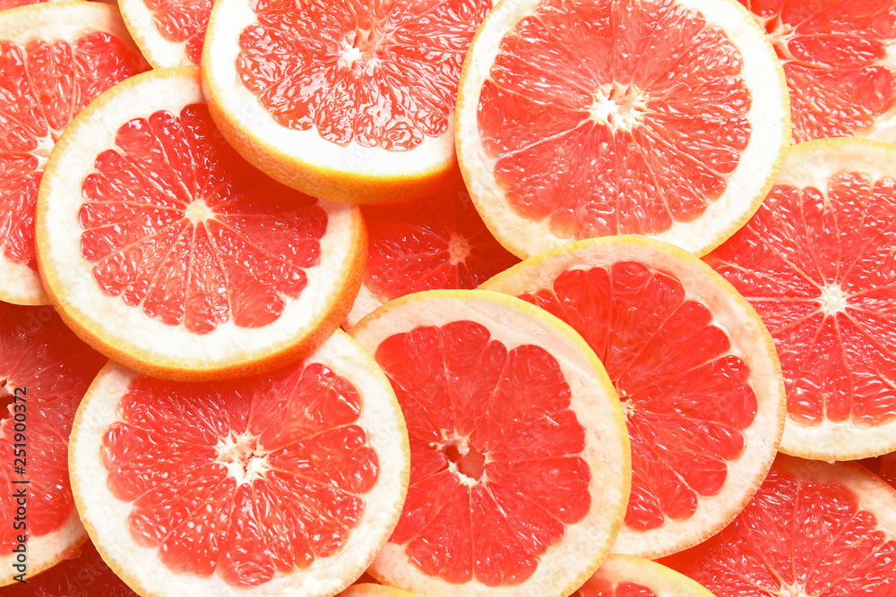 Many sliced fresh grapefruits as background, top view Many sliced fresh grapefruits as background, top view