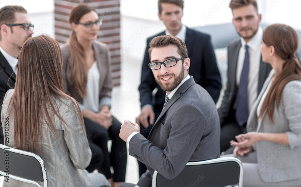 young employee sitting in a circle of colleagues young employee sitting in a circle of colleagues