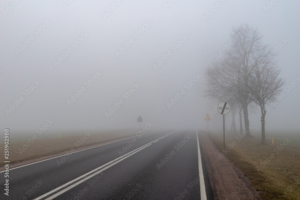 Asphalt road in a big fog. Low visibility on a busy road in Central Europe.