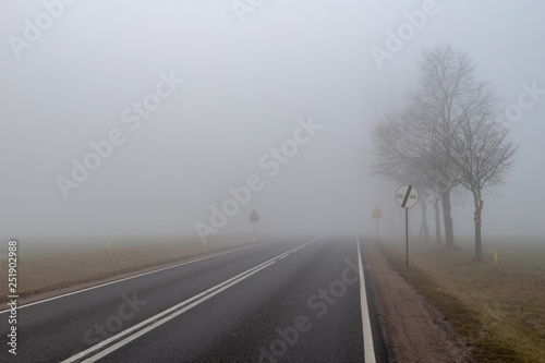Asphalt road in a big fog. Low visibility on a busy road in Central Europe.