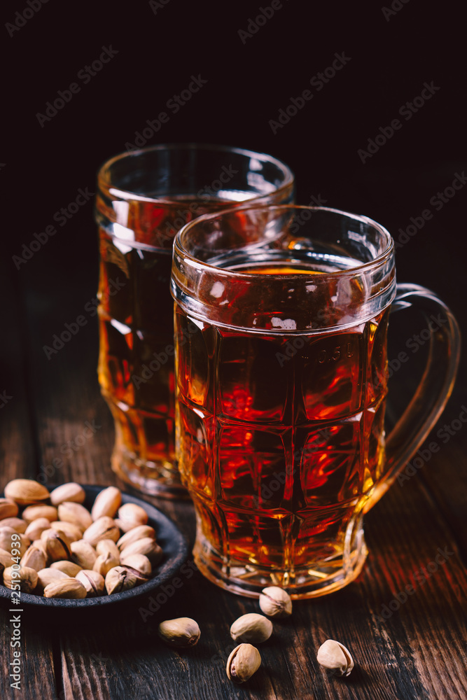 bar table. two mugs of lager beer and snacks set. restaurant, pub, food concept. delicious drink and salty nuts. oktoberfest atmosphere, craft brewery background