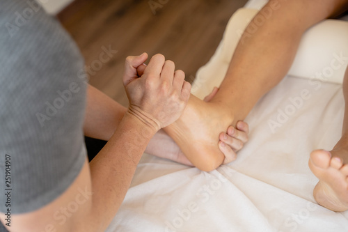 Manos de fisioterapeuta tratando lesión de pie de una mujer