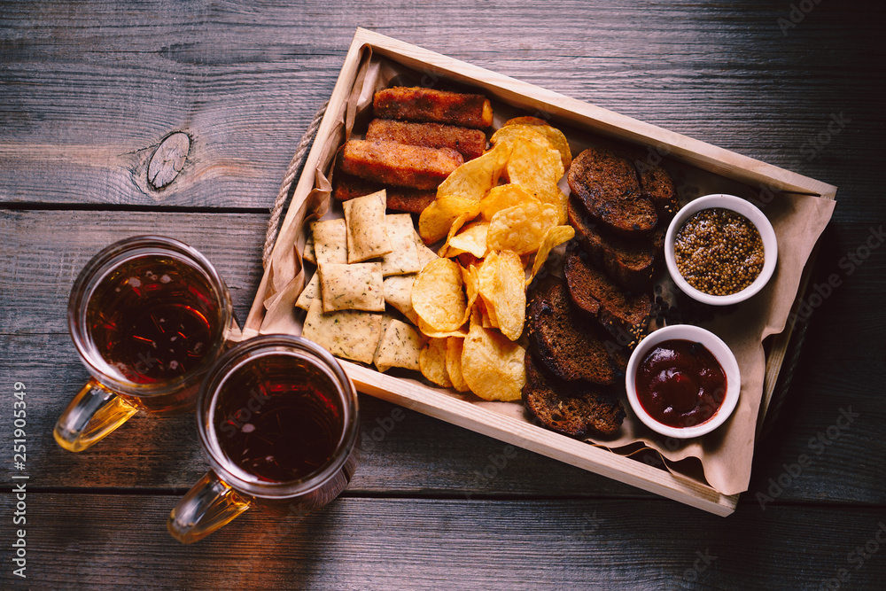 beer and snacks. bar table. restaurant, pub, food concept. delicious lager  drink and appetizers set- toasts, potato chips, crackers and cheese sticks.  friday party atmosphere, craft brewery background фотография Stock | Adobe