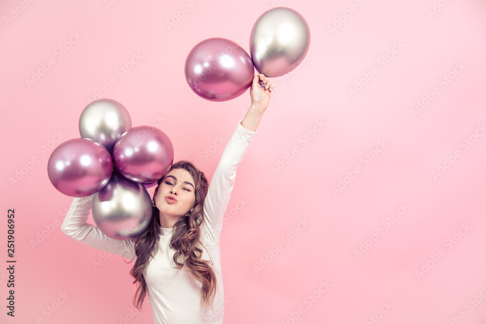 Young girl with balls on a colored background