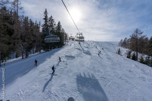 Aussicht von Waidring Steinplatte auf Winterlandschaft mit Schipiste und Schifahrer photo