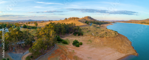 Aerial panorama of Lake Hume and yellow rolling hills at sunset. New South Wales, Australia
