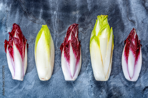 Food background, flat lay concept with fresh green Belgian endive or chicory and red Radicchio vegetables, also known as witlof photo
