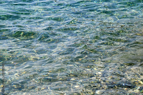 Sunlight reflects on a sea surface. Beautiful clear water. Selective focus.