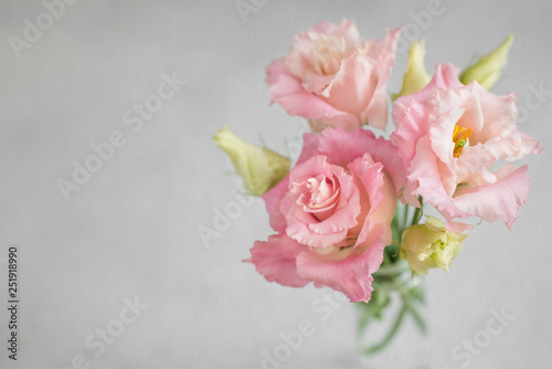 Fresh flowers of Lisianthus on grey painterly photographic texture. Beautiful bouquet of Eustoma. photo