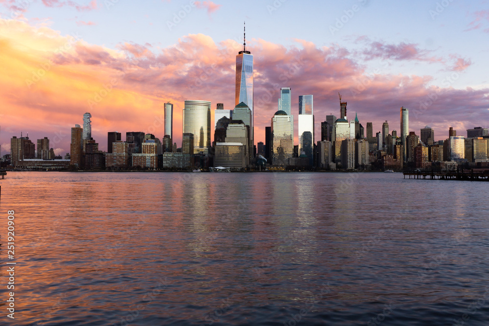 Fototapeta premium Sunset view of Lower Manhattan with reflections in the Hudson River