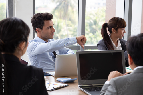 Members who attended the meeting did not agree with the project summary, Businessman showing a disagreement with thumb down at the conference table in the office of company, Disagree briefing concept