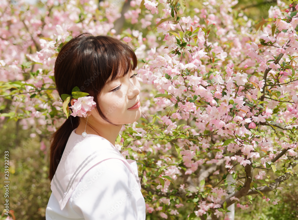 Outdoor portrait of beautiful young Chinese girl smiling among blossom cherry tree brunch in spring garden, beauty, summer, emotion, expression and people lifestyle concept. Outdoor portrait of beautiful young Chinese girl smiling among blossom cherry tree brunch in spring garden, beauty, summer, emotion, expression and people lifestyle concept.