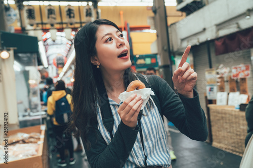 girl backpacker eating snack sweet donuts photo