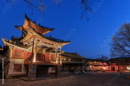 Shaxi, China - February 21, 2019: Central square of Shaxi old town at sunset with the old theater illuminated